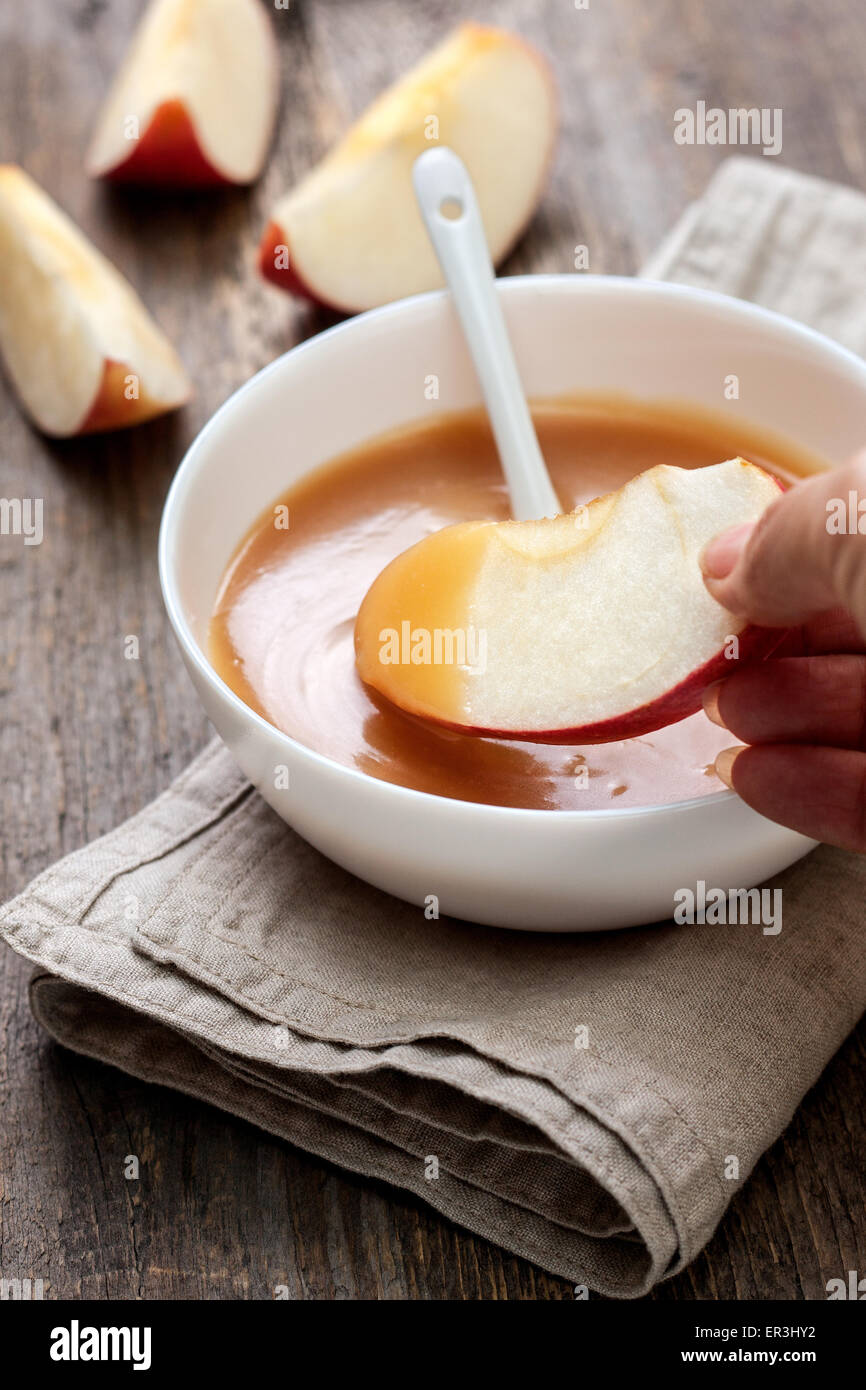 La salsa di caramello in una ciotola e fette di mela Foto Stock