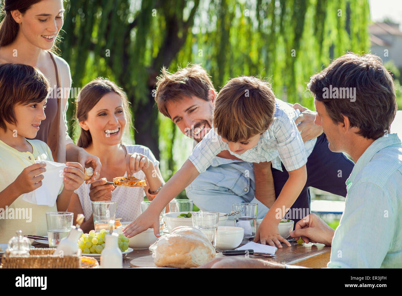 Famiglia gustando la prima colazione insieme all'aperto Foto Stock