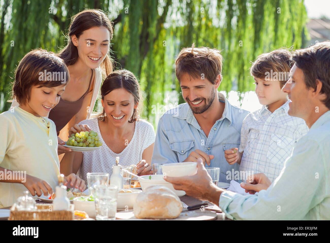Famiglia gustando la prima colazione insieme all'aperto Foto Stock