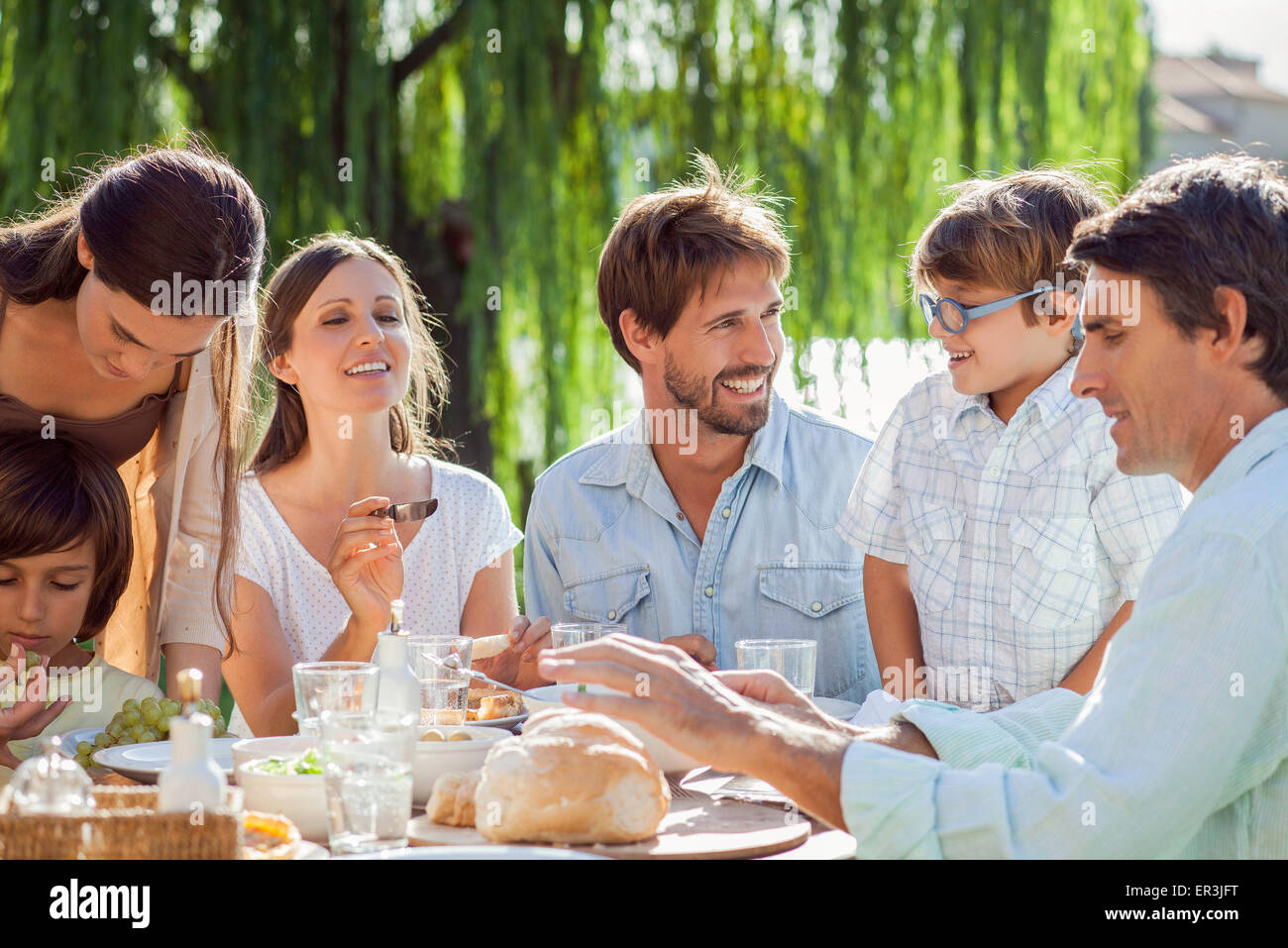 Famiglia gustando la prima colazione insieme all'aperto Foto Stock