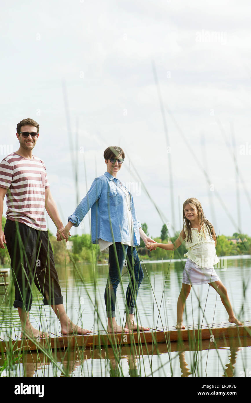 Famiglia tenendo le mani sul dock, ritratto Foto Stock