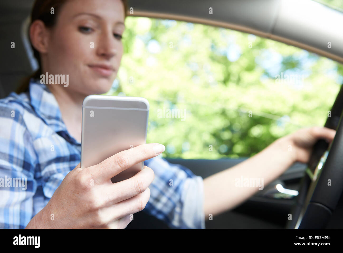 La donna in auto gli sms sul cellulare durante la guida Foto Stock