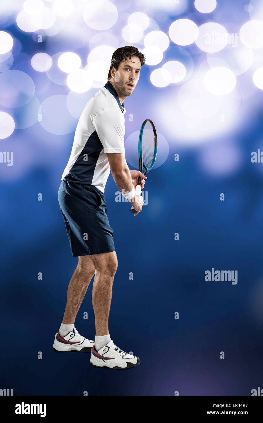 Giocatore di tennis giocando sulle luci blu sullo sfondo. Foto Stock