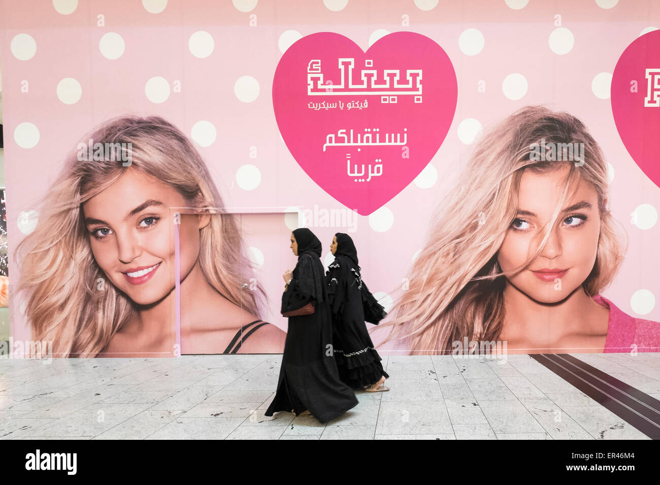 Le donne a piedi passato affissioni per nuovo Victoria's Secret shop in City Center shopping mall di Manama Regno del Bahrein Foto Stock