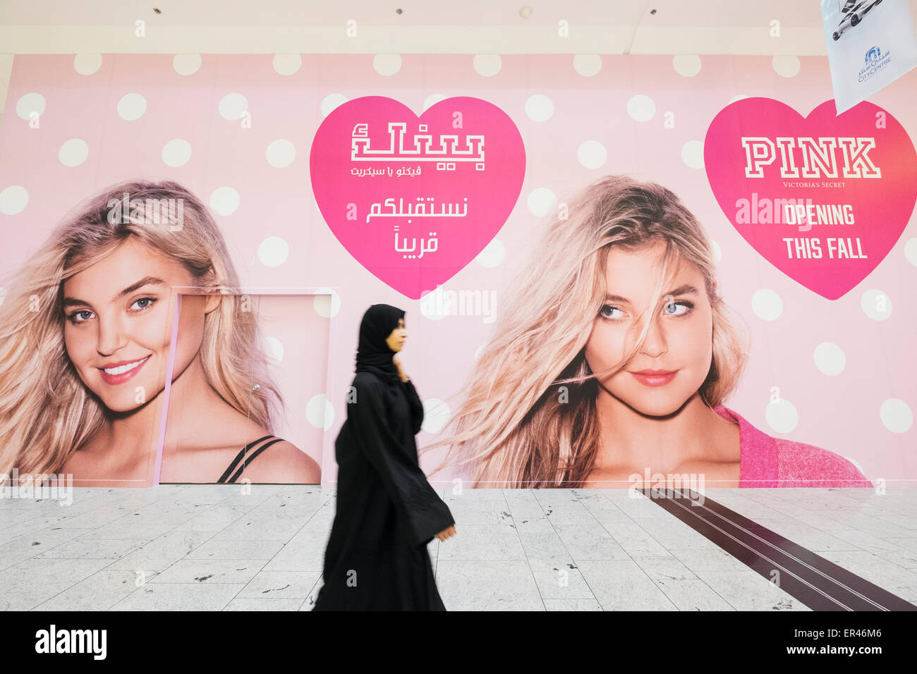 La donna a piedi passato affissioni per nuovo Victoria's Secret shop in City Center shopping mall di Manama Regno del Bahrein Foto Stock