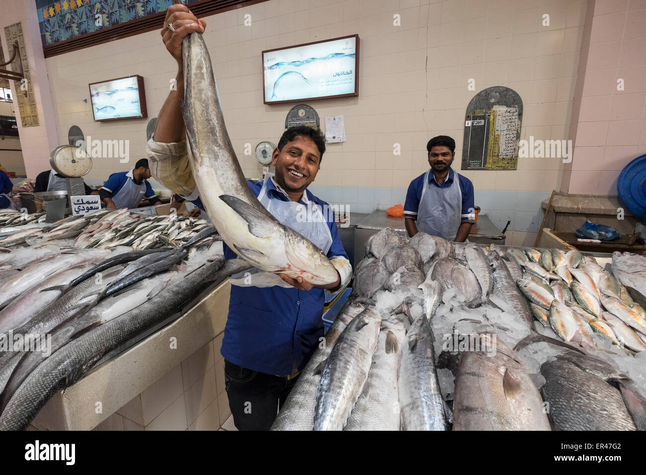 L'uomo tenendo il pesce per la vendita al mercato del pesce al Souq Sharq in Kuwait City in Kuwait. Foto Stock