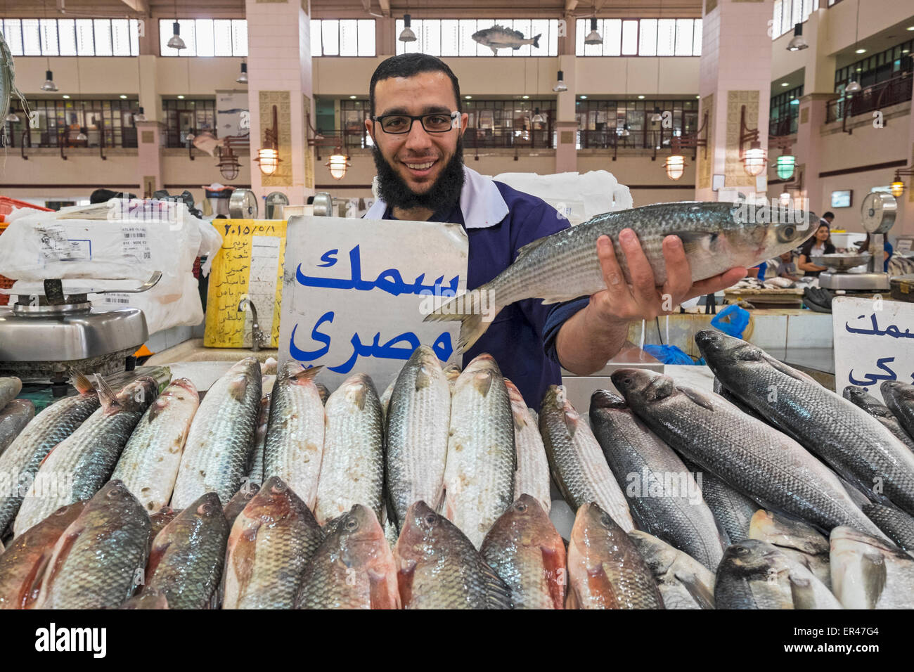 L'uomo tenendo il pesce per la vendita al mercato del pesce al Souq Sharq in Kuwait City in Kuwait. Foto Stock