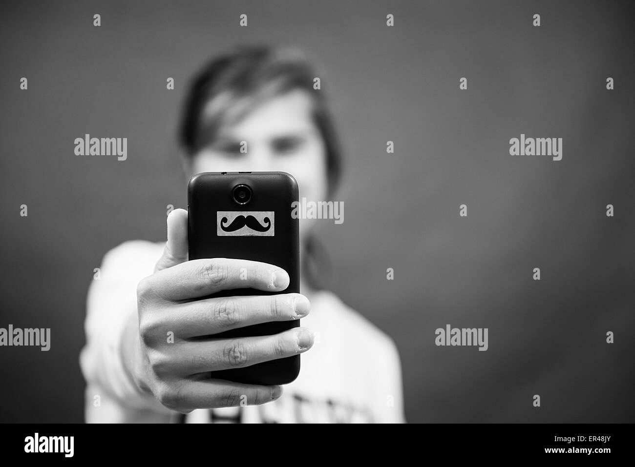 Ragazza con un telefono in mano è di scattare una foto di sé Foto Stock