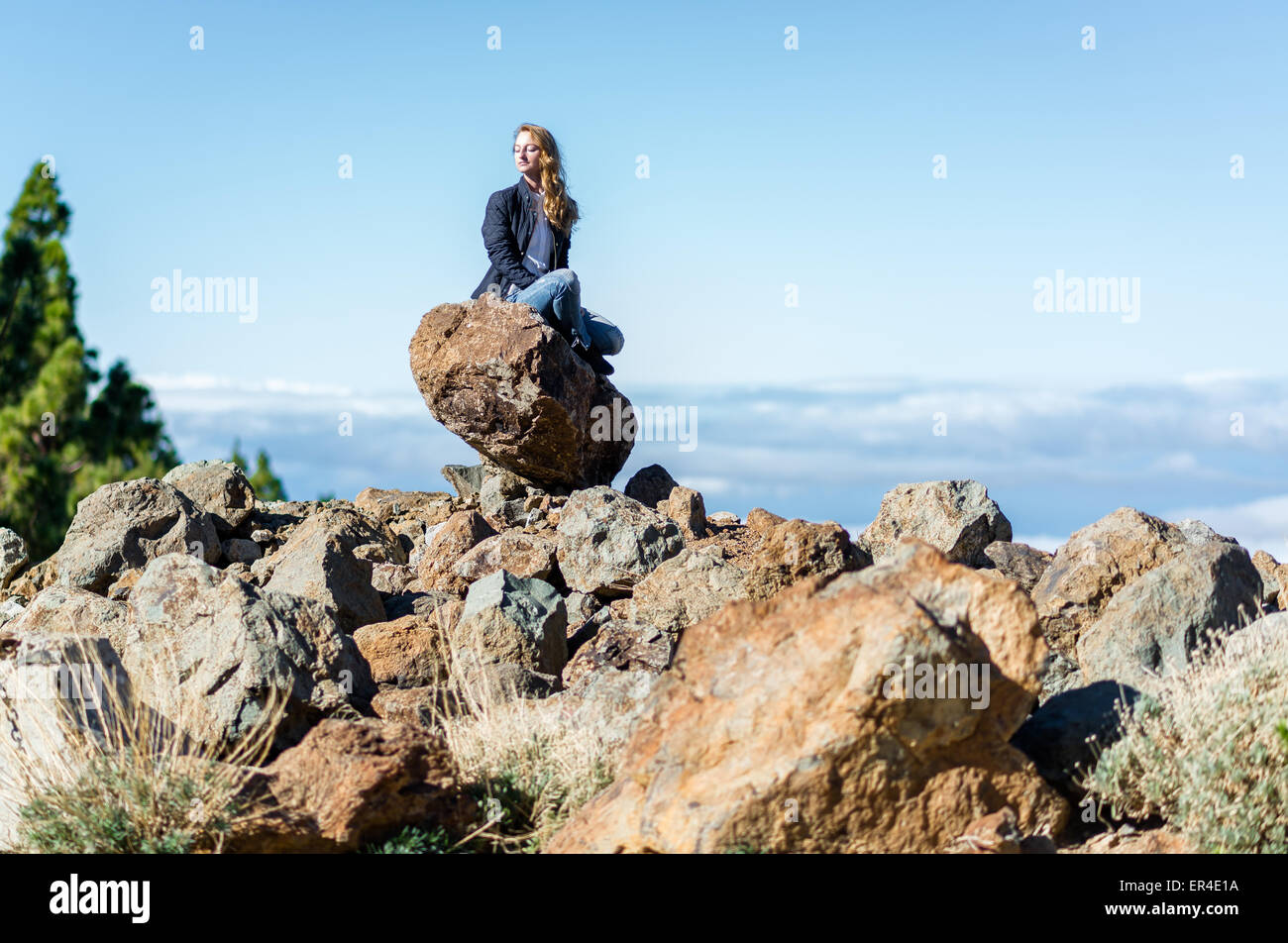 Donna seduta su una roccia Foto Stock