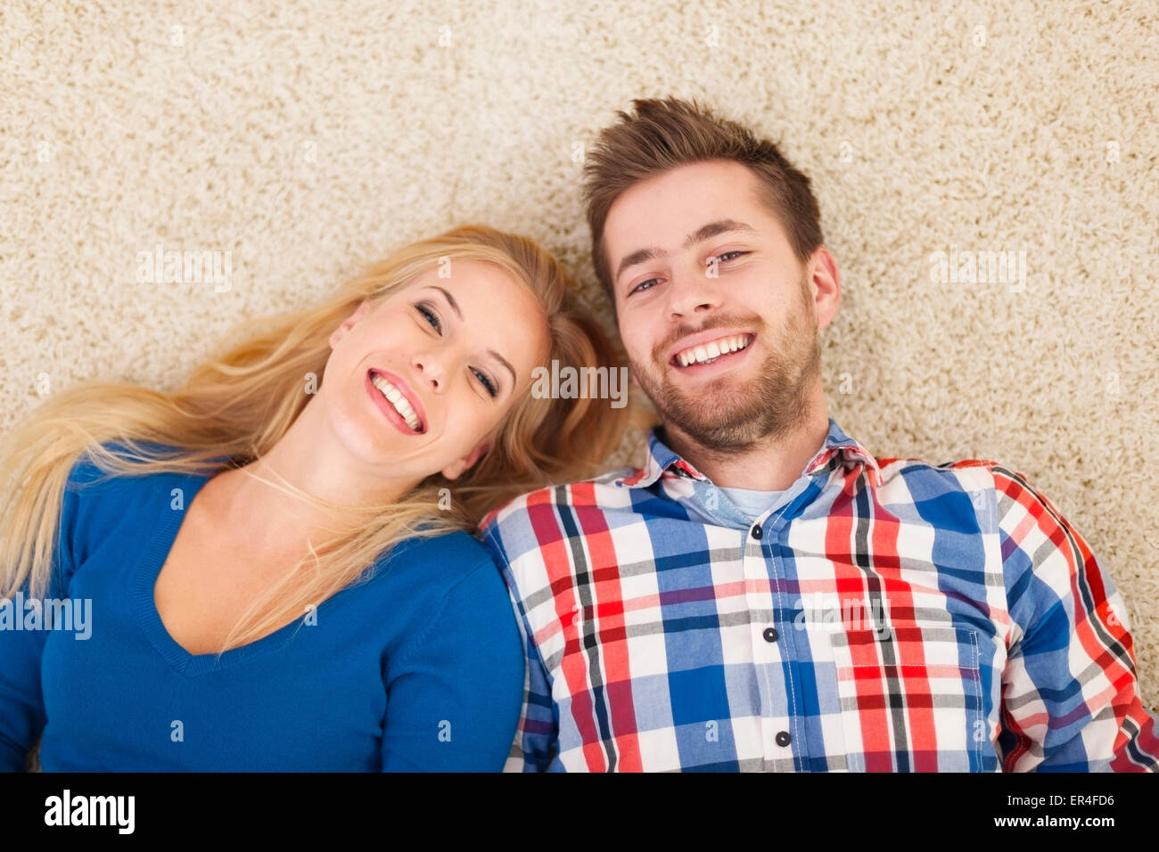Ritratto di coppia felice sdraiato su un tappeto Foto Stock
