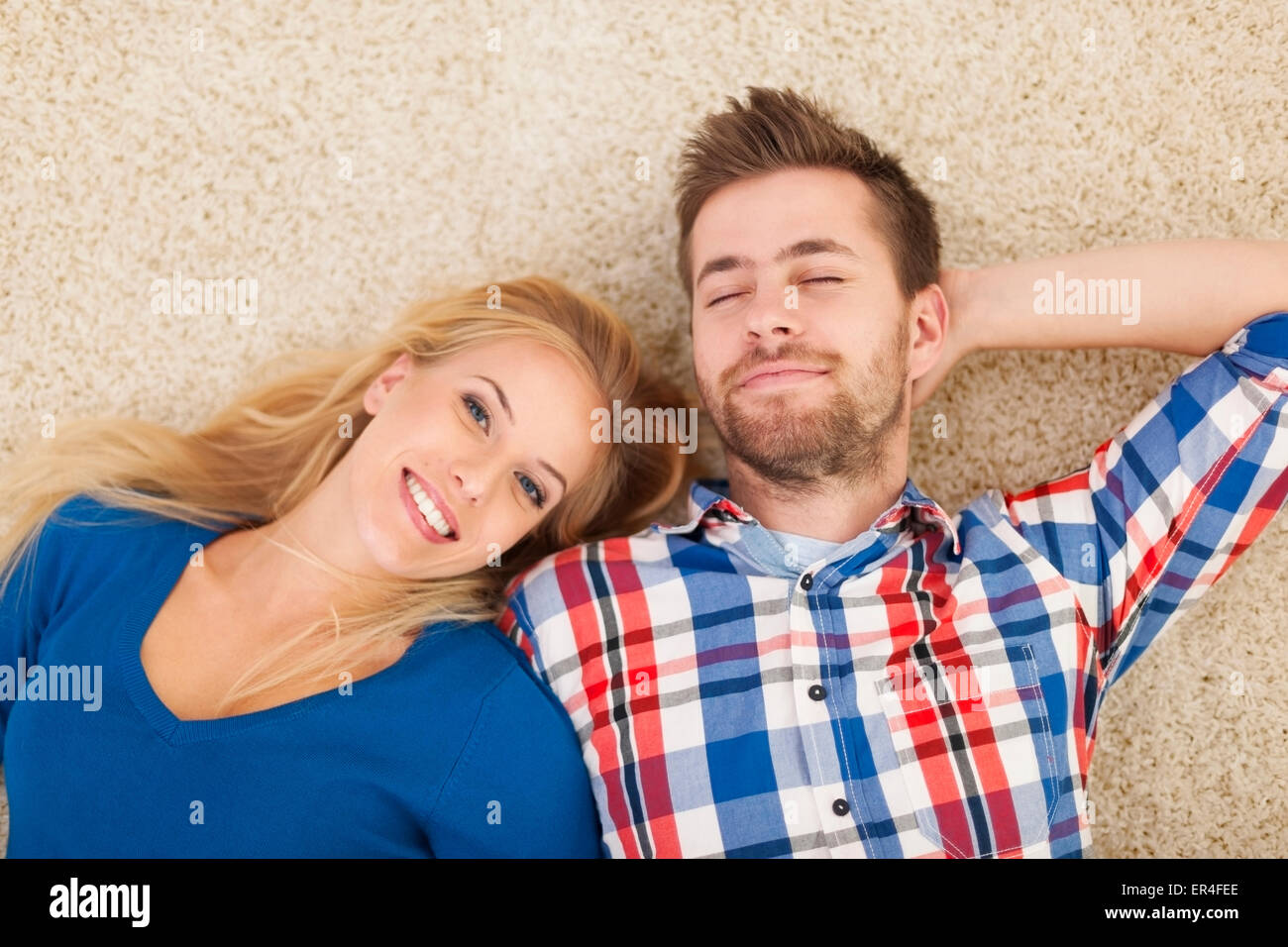 Ritratto di coppia giovane sdraiato su un tappeto Foto Stock