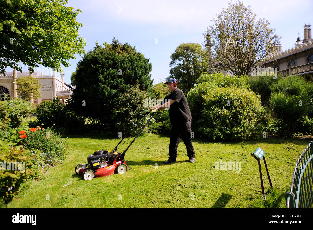 Brighton Regno Unito 27 maggio 2015 - Robert Hill-Snook il capo giardiniere a Brighton Royal Pavilion Gardens la falciatura di prati in tempo caldo questa mattina Credito: Simon Dack/Alamy Live News Foto Stock