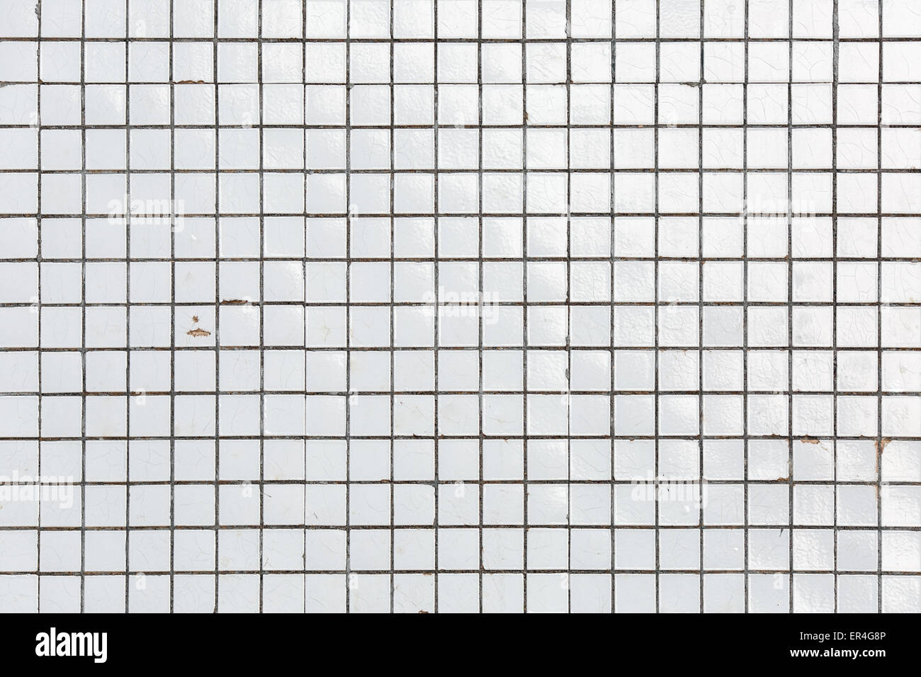 Bianco vecchio e obsoleto danneggiato parete piastrellata come una texture o dello sfondo. White piastrelle di ceramica. Foto Stock