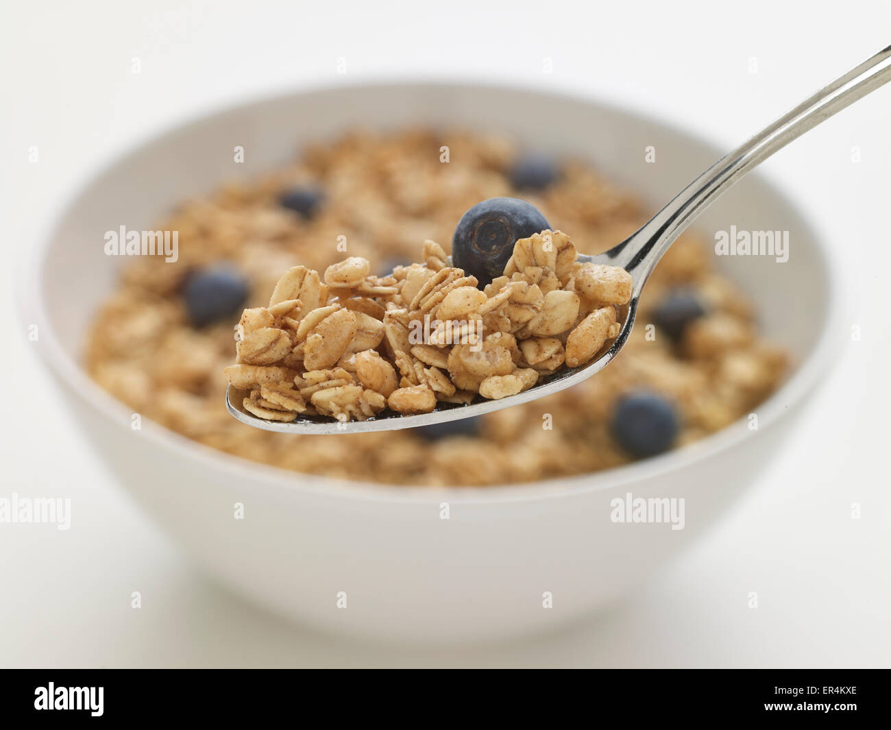Cucchiaio di cereali granola con ciotola bianco Foto Stock