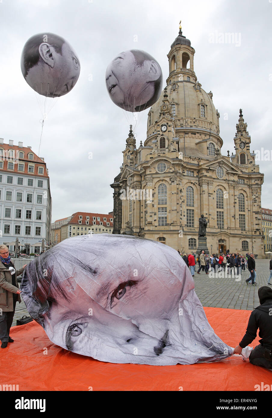 Palloncini di avvocatura di sviluppo e organizzazione di campagne di sensibilizzazione 'un' raffigurante il Cancelliere tedesco Angela Merkel (CDU, anteriore), il Primo Ministro britannico David Cameron (l)e il Primo Ministro giapponese Shinzo Abe (r) passate davanti alla Frauenkirche di Dresda Dresda, in Germania, il 27 maggio 2015. Una riunione del G7 dei Ministri delle Finanze e i governatori della Banca centrale si svolge nella capitale della Sassonia dal 27 al 29 Maggio. Foto: JAN WOITAS/dpa Foto Stock