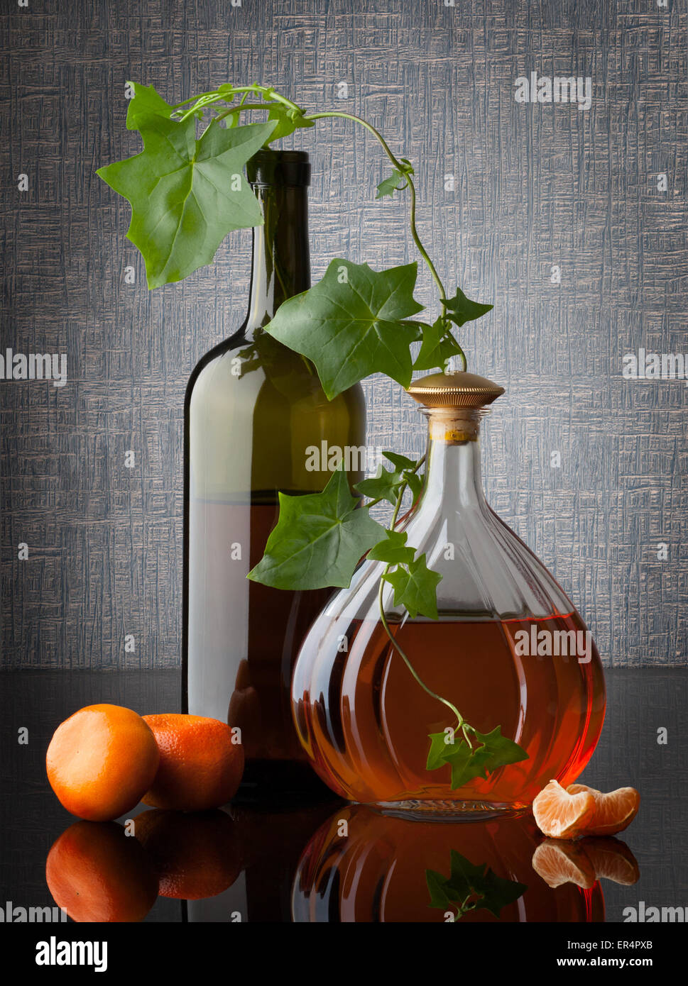 Ancora vita composizione con bottiglie di foglie e di mandarini su sfondo scuro Foto Stock
