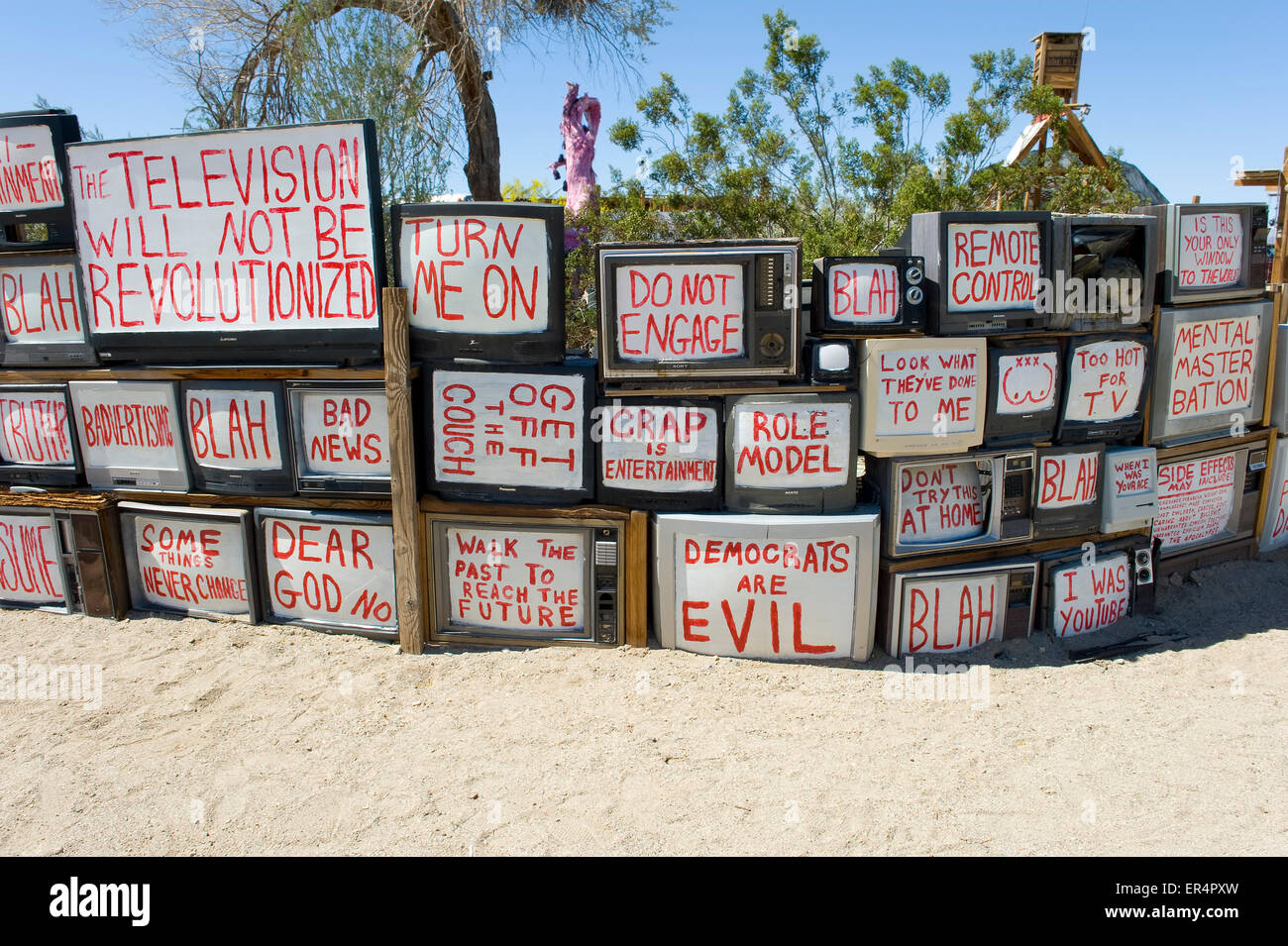 Una parete di televisori con slogan politici , Oriente Gesù, Lastra Città, Niland, nel sud della California, Stati Uniti d'America. Foto Stock