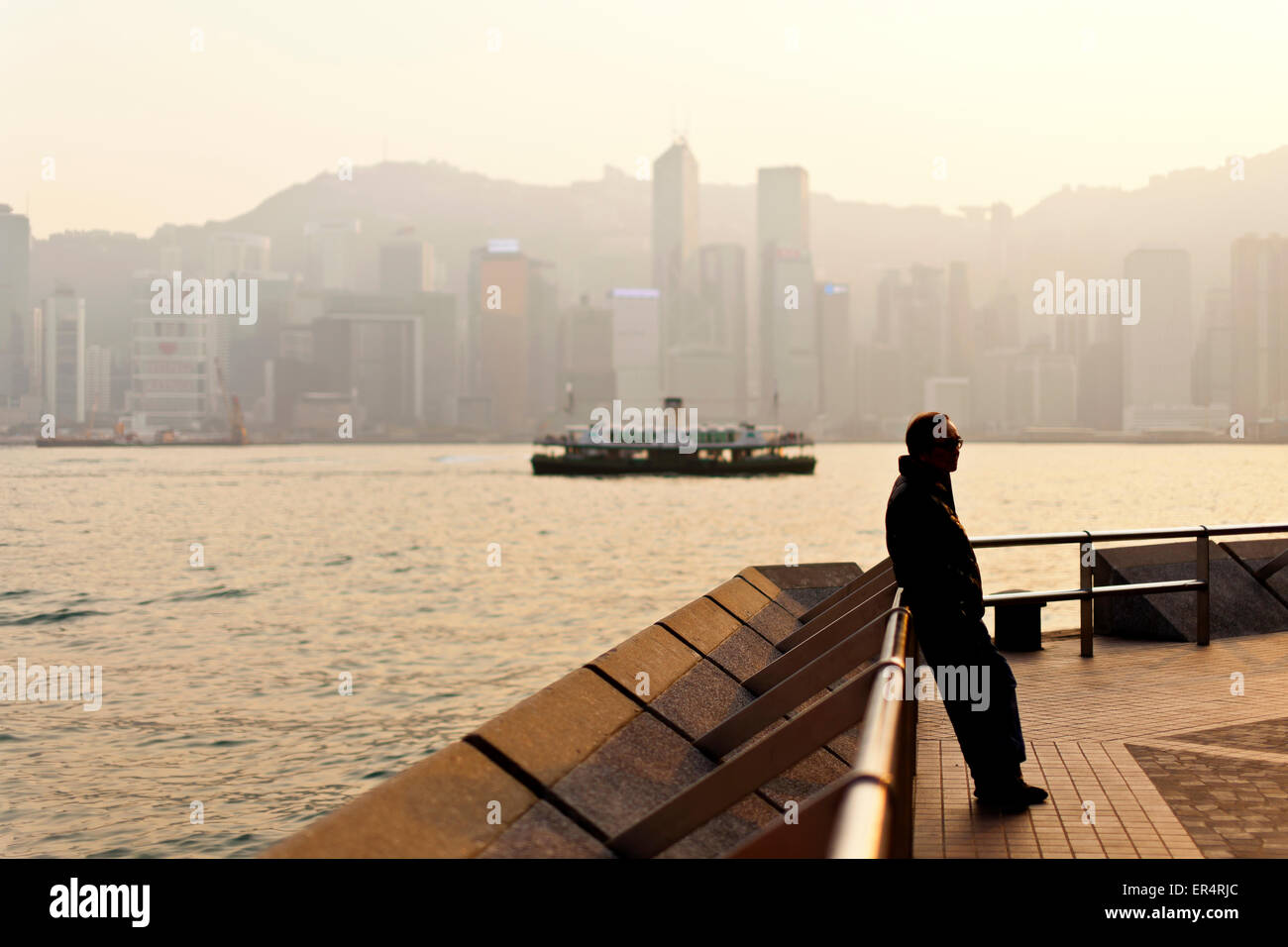Uomo in piedi lungo il Victoria Harbour Foto Stock