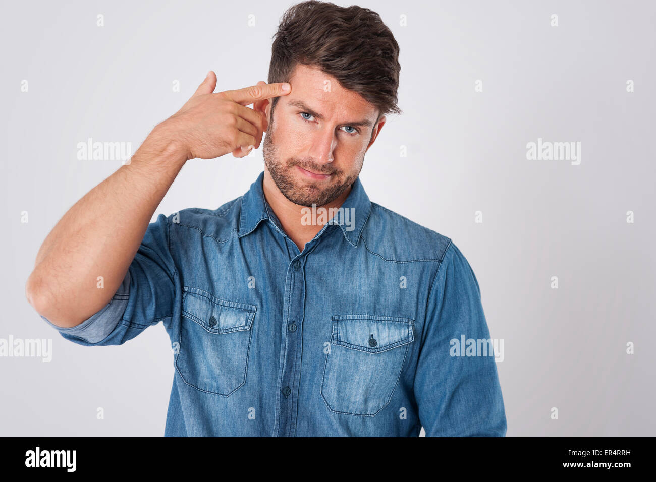 L uomo del dito puntato gesto di pistola alla testa. Debica, Polonia Foto Stock