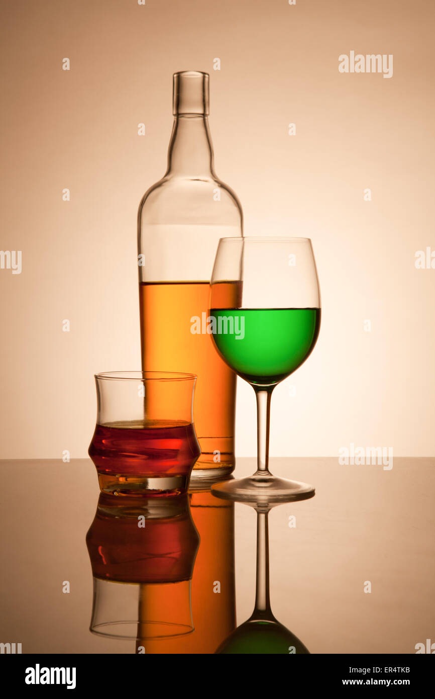 Ancora vita composizione con bicchieri e bottiglie riempite con liquidi colorati Foto Stock