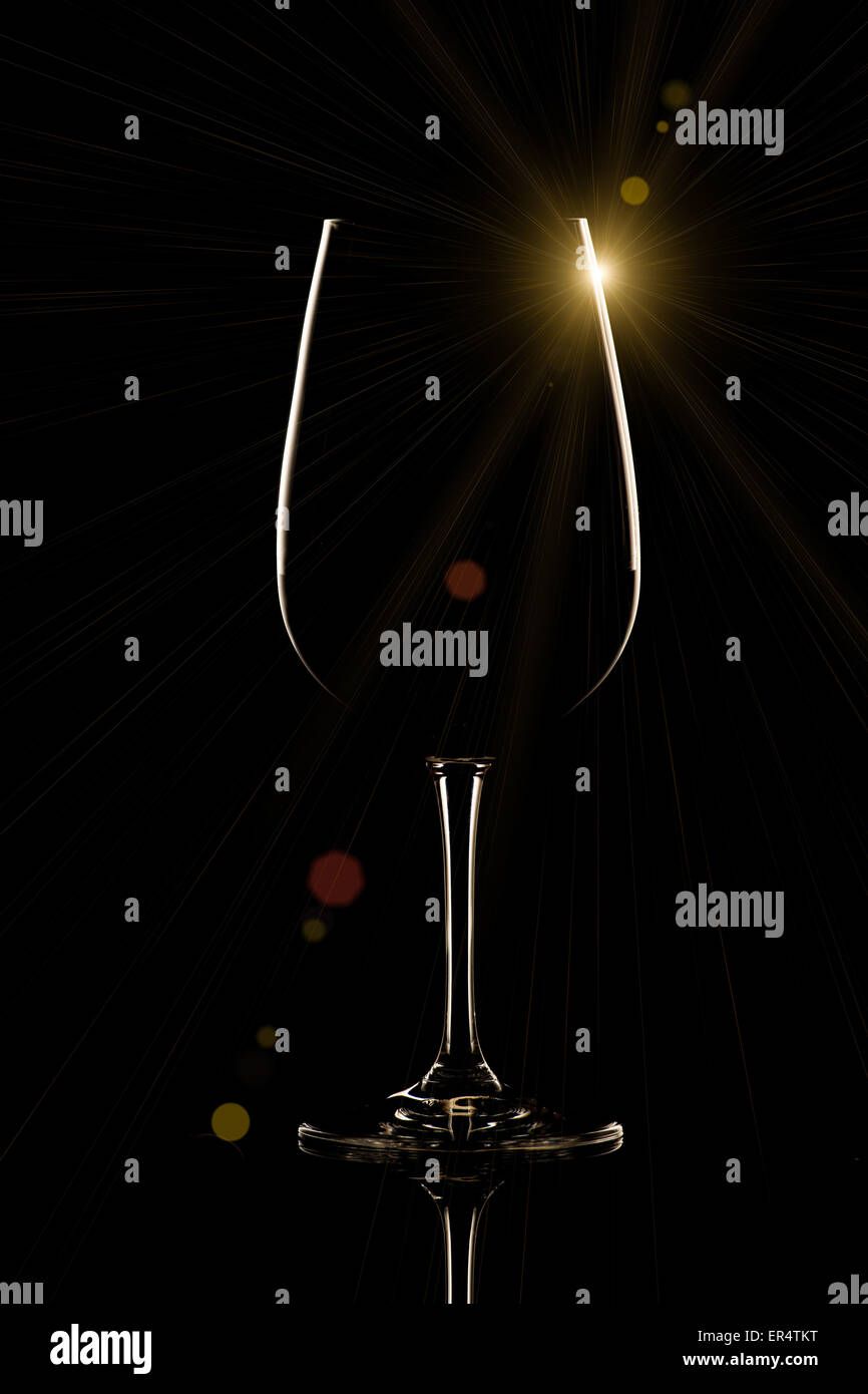 Bicchiere di vino su sfondo nero con sun flare Foto Stock
