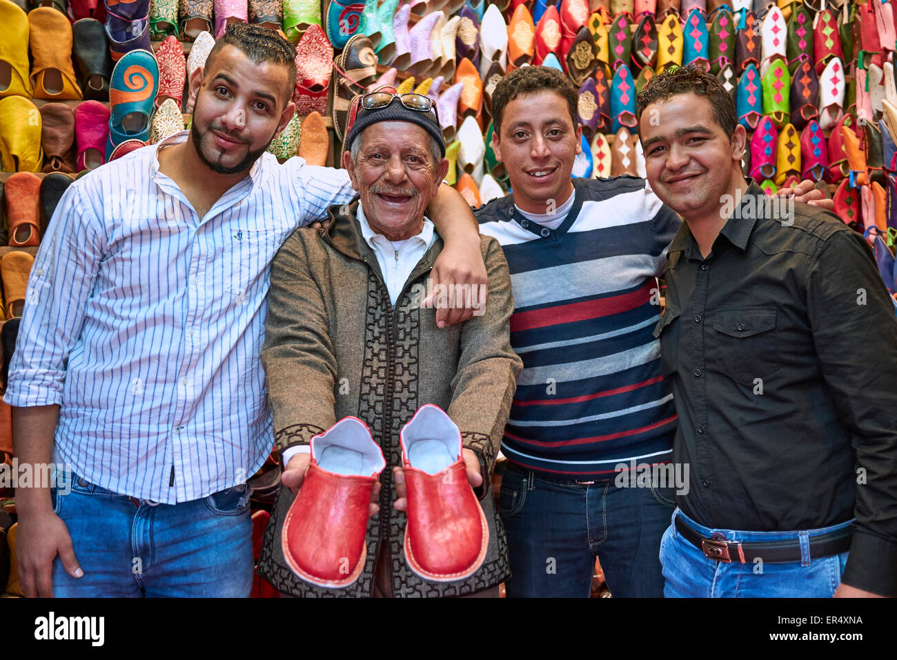 Pantofola proprietario del negozio con i suoi figli. - Marrakech piazza del mercato, Jeema el fnaa Foto Stock