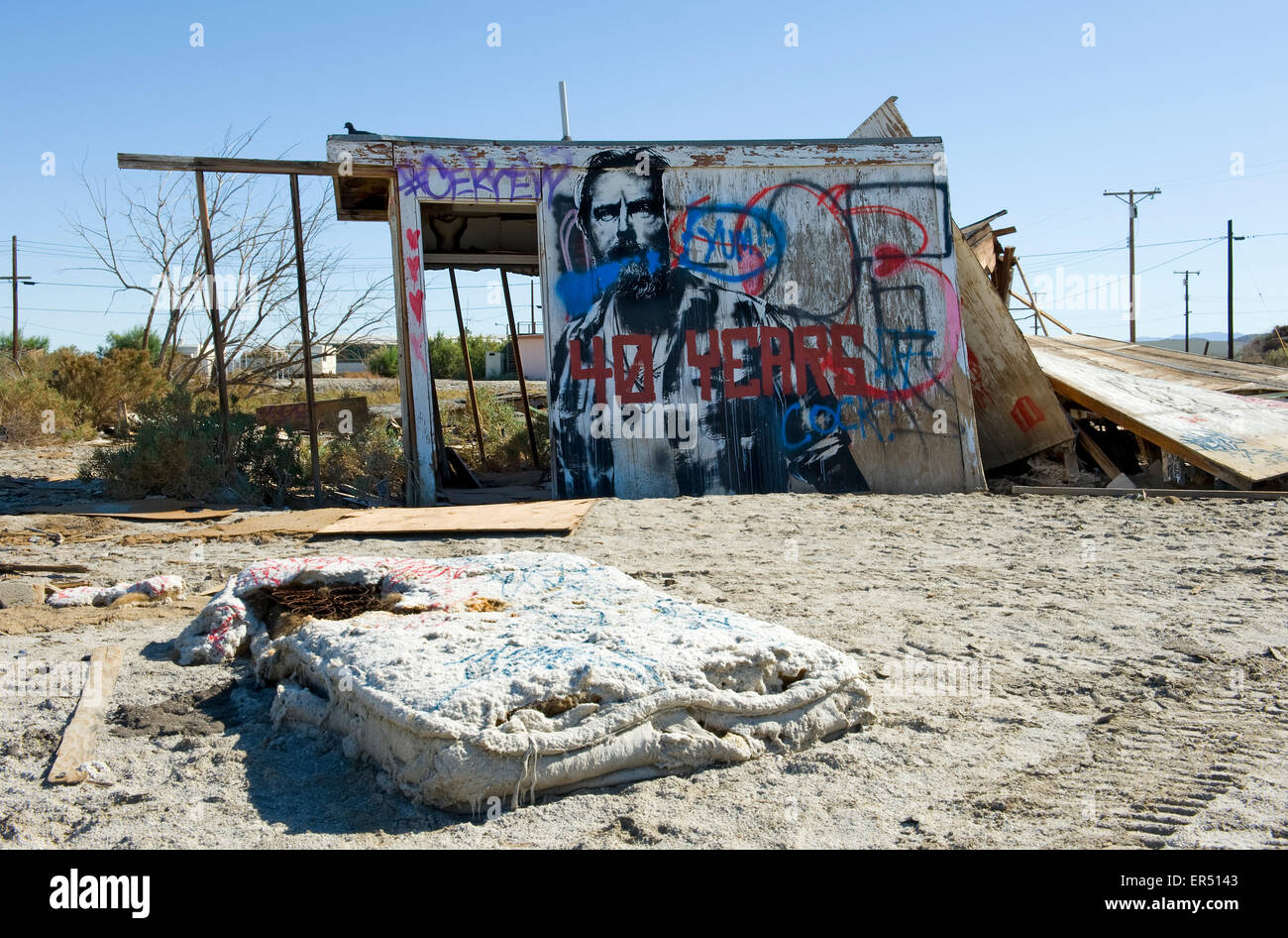 Capanna abbandonata coperto di graffiti con materasso in primo piano, Salton Sea Beach, nel sud della California, Stati Uniti d'America Foto Stock