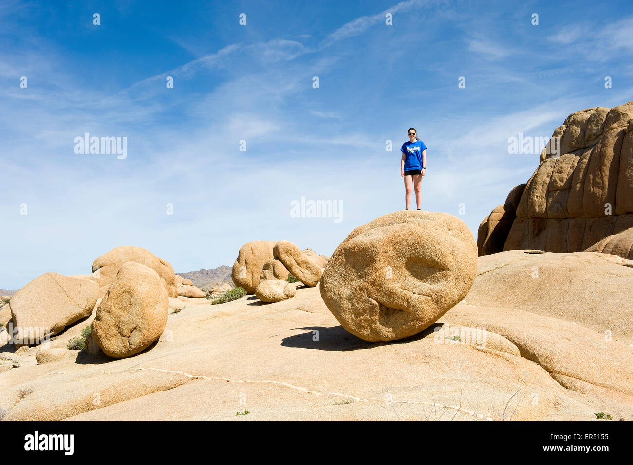 Paesaggio del Deserto Mojave con la ragazza in piedi sul grande masso rotondo,Souther California, Stati Uniti d'America. Foto Stock