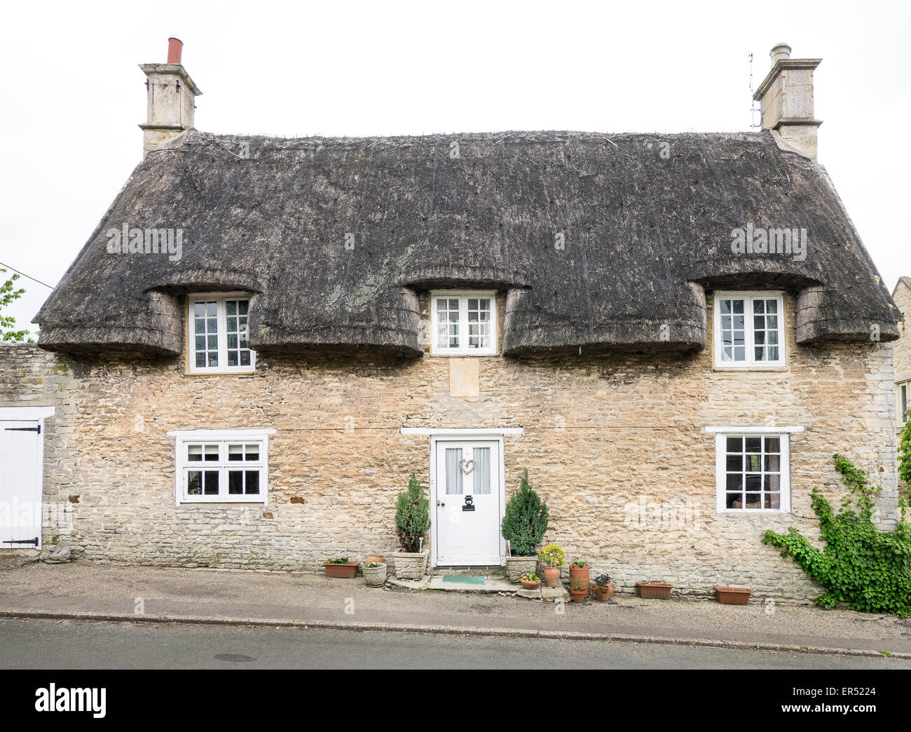 Un diciassettesimo secolo cottage con il tetto di paglia, precedentemente noto come il negozio di paese, nel villaggio di Wadenhoe, che si trova accanto al fiume Nene in Foto Stock