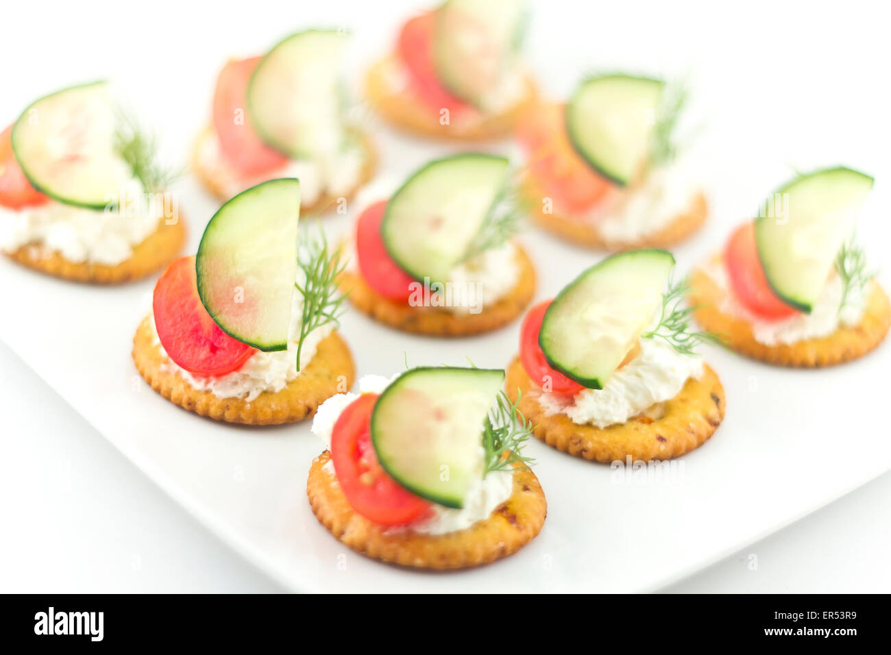 Piastra di snack di cracker conditi con pomodoro aneto di cetriolo e formaggio Foto Stock