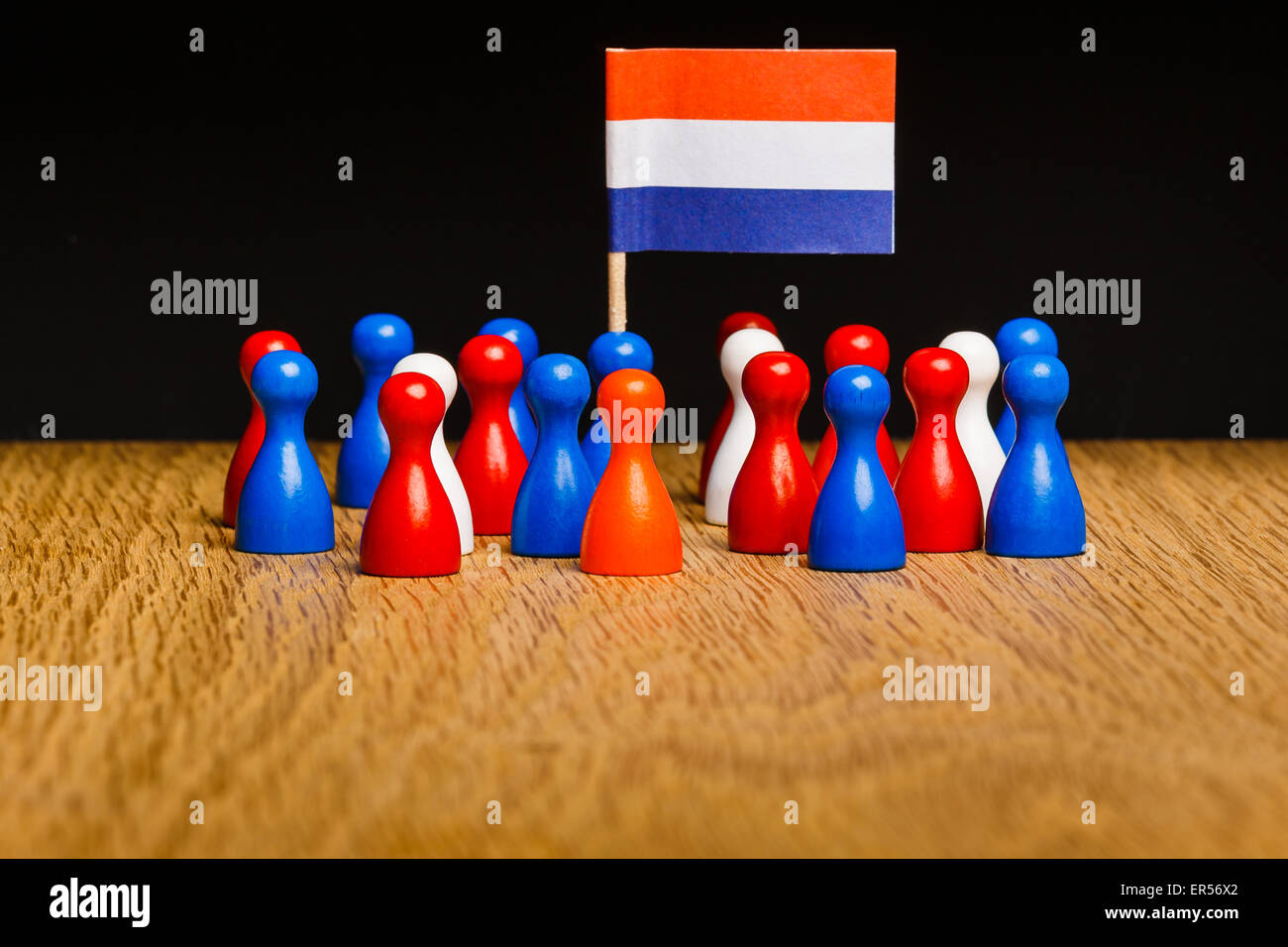 Concept per il Regno dei Paesi Bassi. Orange re, kingsday, rosso bianco blu pedine intorno e bandiera. Foto Stock