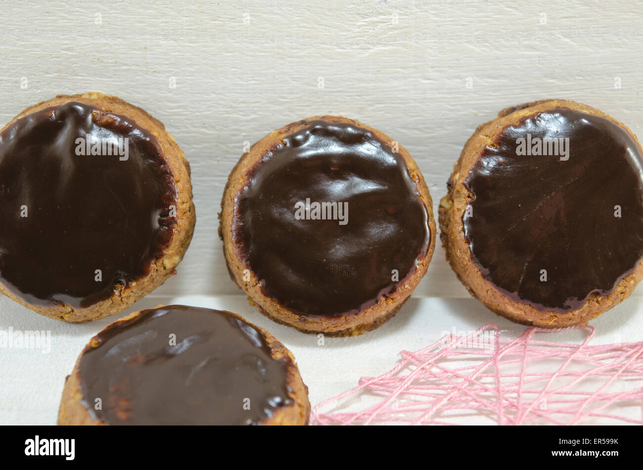 Biscotti con cioccolato fondente in piedi contro un pannello di legno Foto Stock