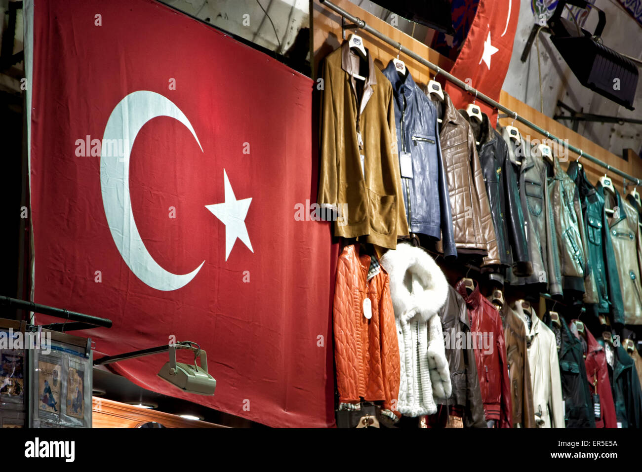 Una bandiera turca e altri articoli di abbigliamento per la vendita in un bazar market. Foto Stock