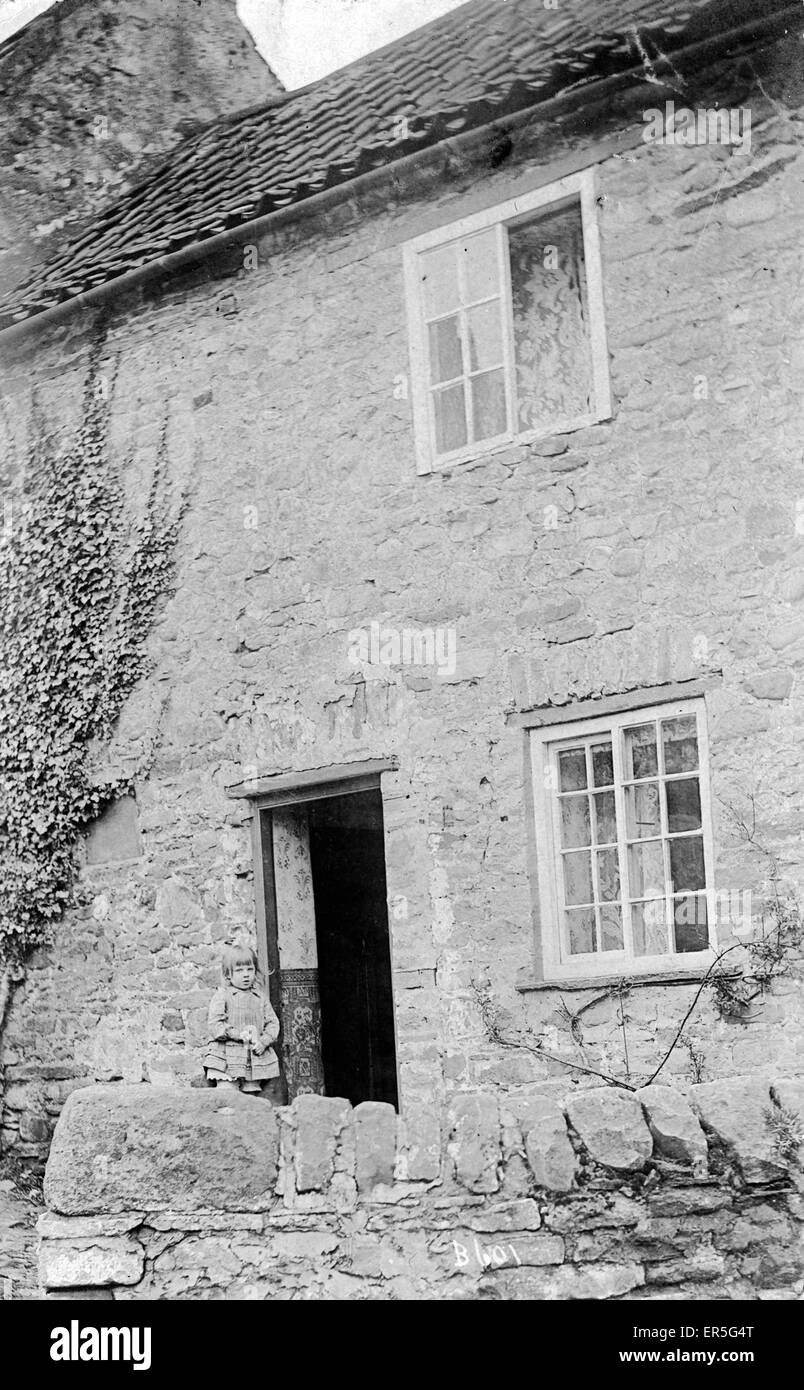 Piccola ragazza fuori di un vecchio Cottage o Farmhouse Foto Stock