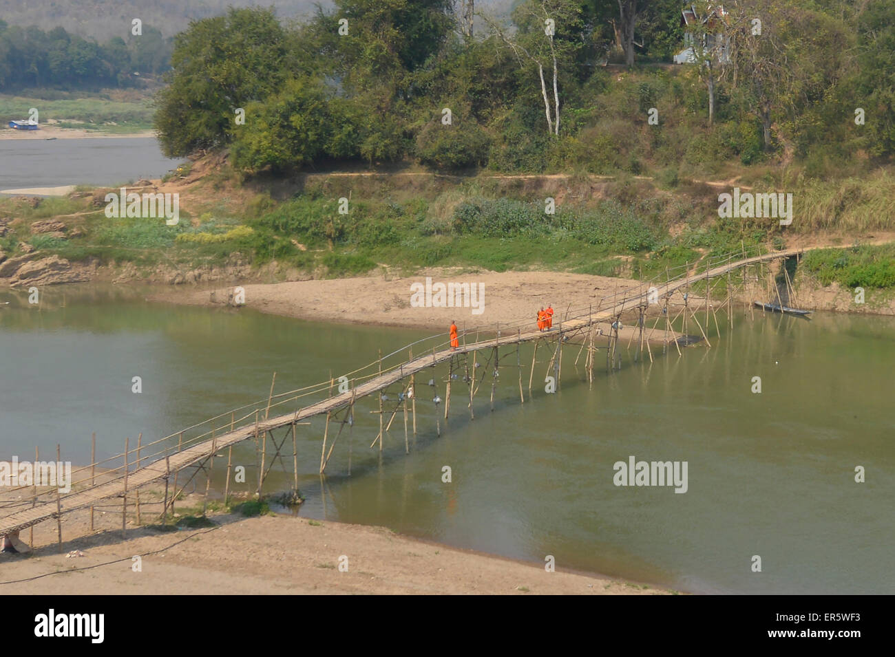 Monaci su un ponte di bambù dal fiume Mekong, Luang Prabang, Laos Foto Stock