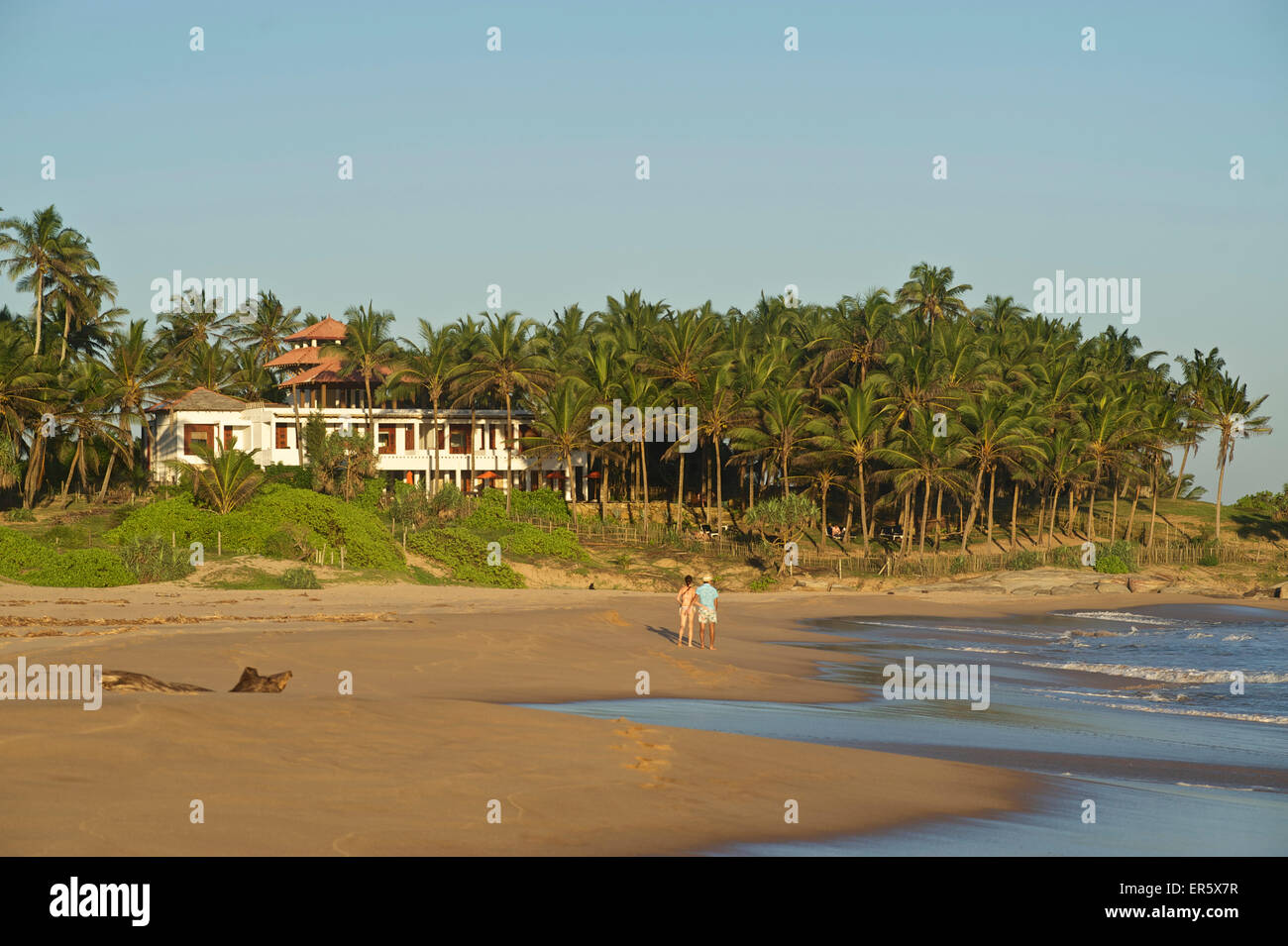 Due turisti su una spiaggia deserta, Turtle Bay Hotel in background, Tangalle, Sud Sri Lanka Foto Stock