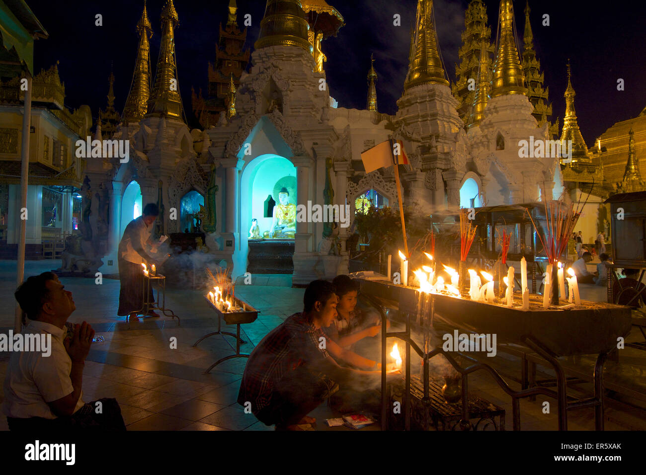 Popolo birmano accendendo candele alla Shwedagon Paya, Yangon, Rangoon, MYANMAR Birmania Foto Stock