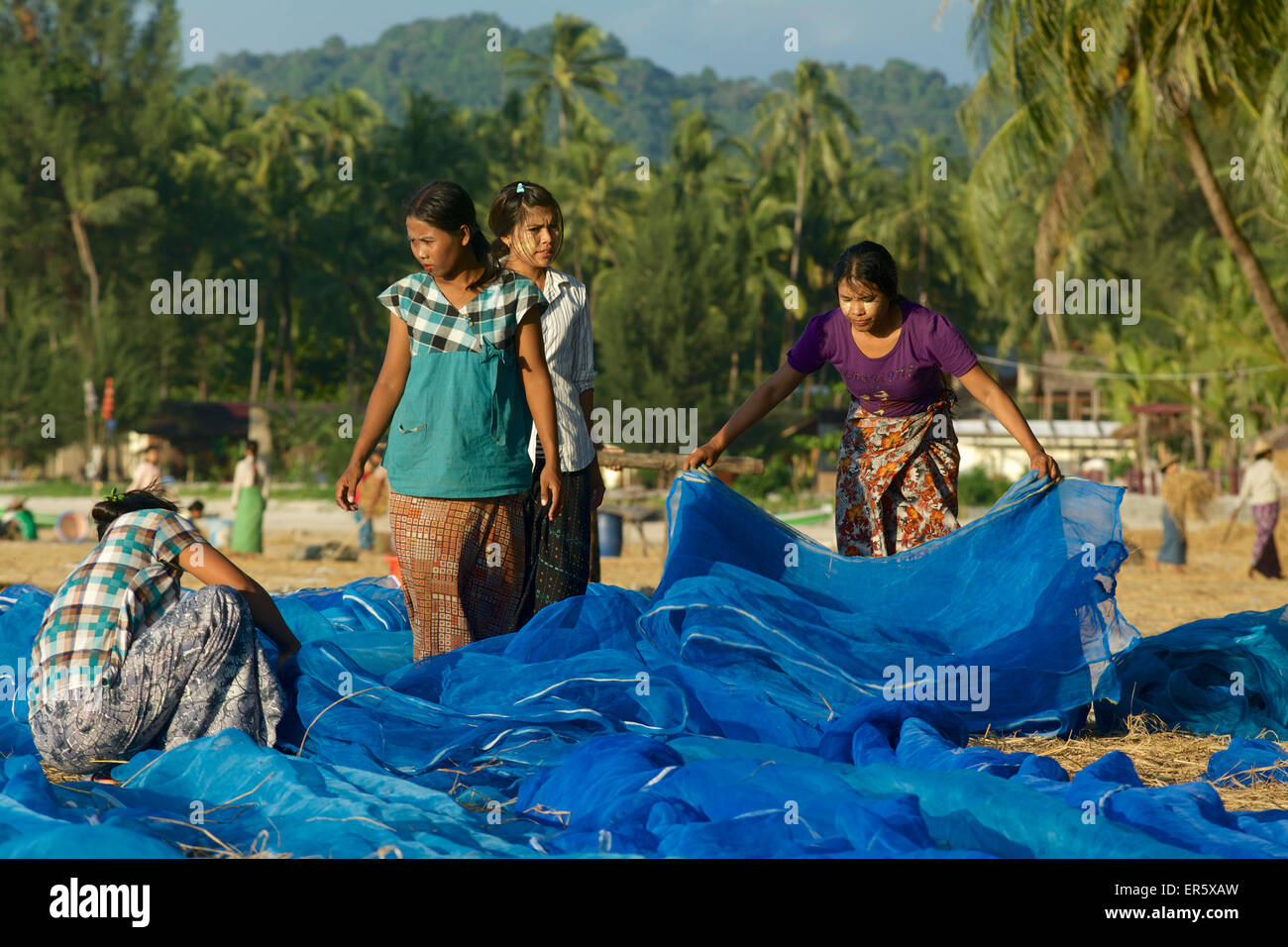 Le donne del villaggio di pescatori di pulizia Lonthar reti, Ngapali, più famosi beach resort in Birmania alla Baia del Bengala, Rakhai Foto Stock