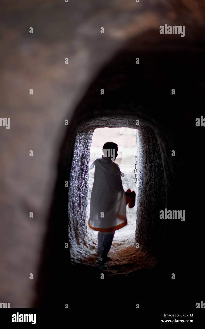 L'uomo all'interno di un tunnel di roccia alla chiesa monolitica Bete Medhane Alem, Chiesa di San Giorgio di Lalibela, Amhara Region, Etiopia Foto Stock