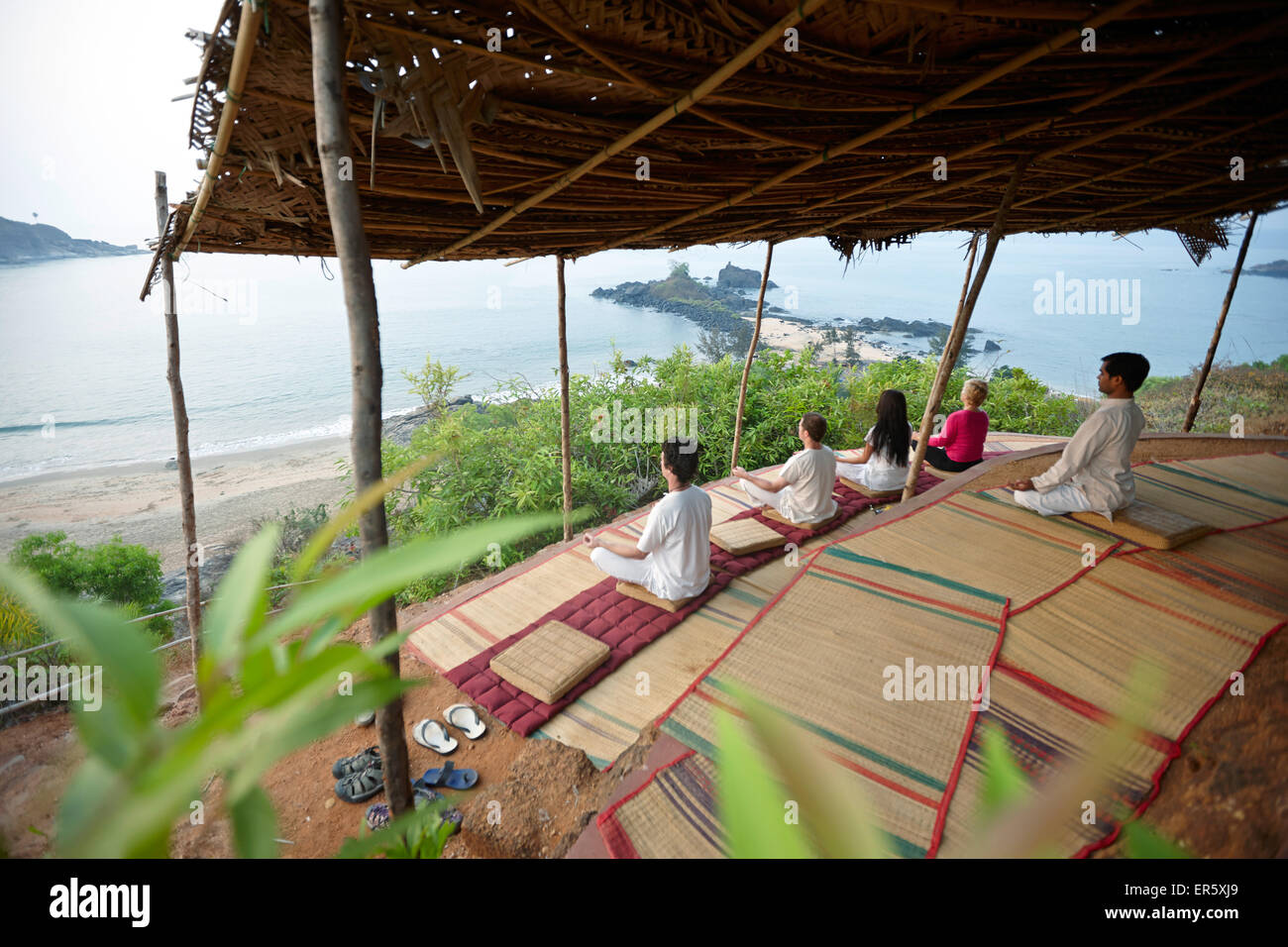 La meditazione prima del sorgere del sole sopra la spiaggia di Om, Gokarna, Karnataka, India Foto Stock