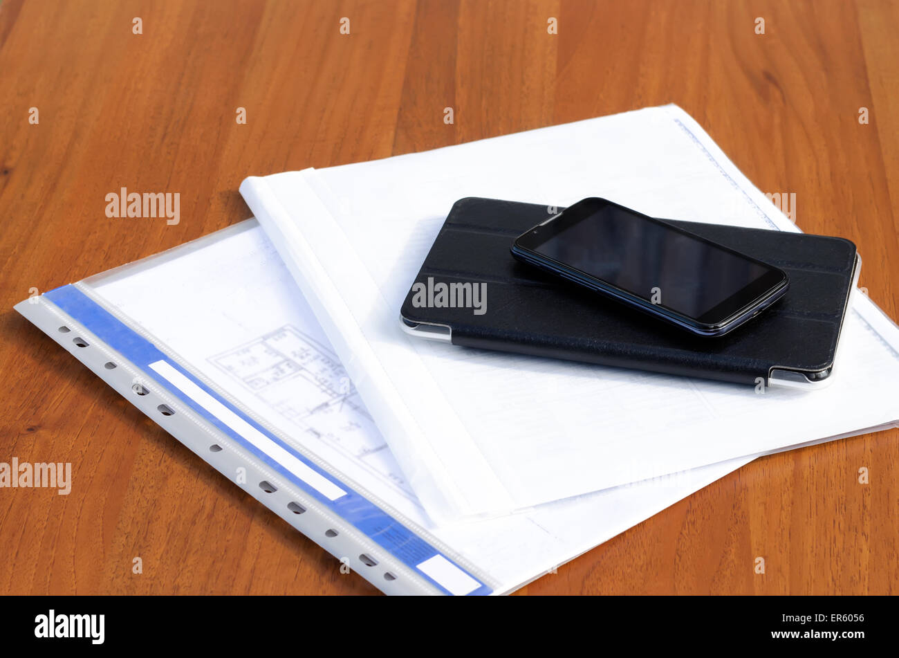 Telefono con il tablet e documenti su un tavolo Foto Stock
