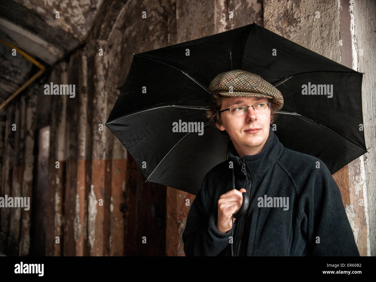 Caucasica uomo polacco tenendo un ombrello nero in ingresso alla porta di appartamento edificio, distretto di Praga, Varsavia, Polonia, Europa Foto Stock