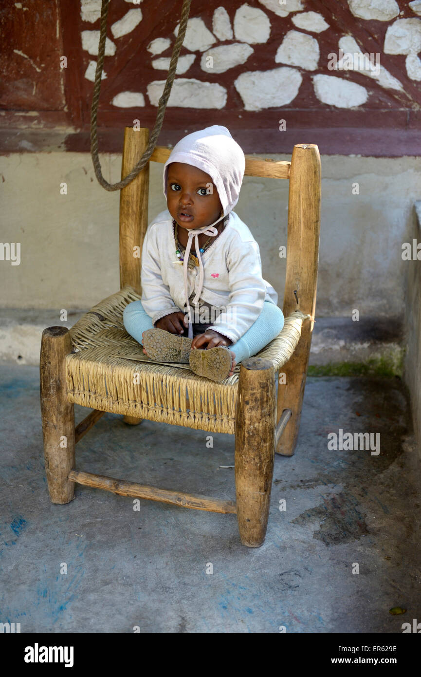 Bambino seduto su una sedia, Riviere Froide, Ouest Reparto, Haiti Foto Stock
