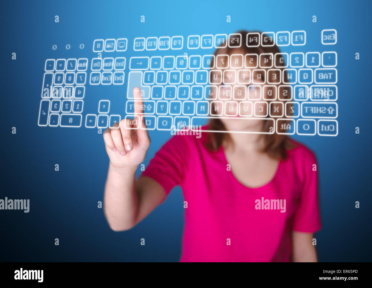 Ragazza in piedi di fronte a schermo virtuale, premendo il tasto di invio sulla tastiera Foto Stock