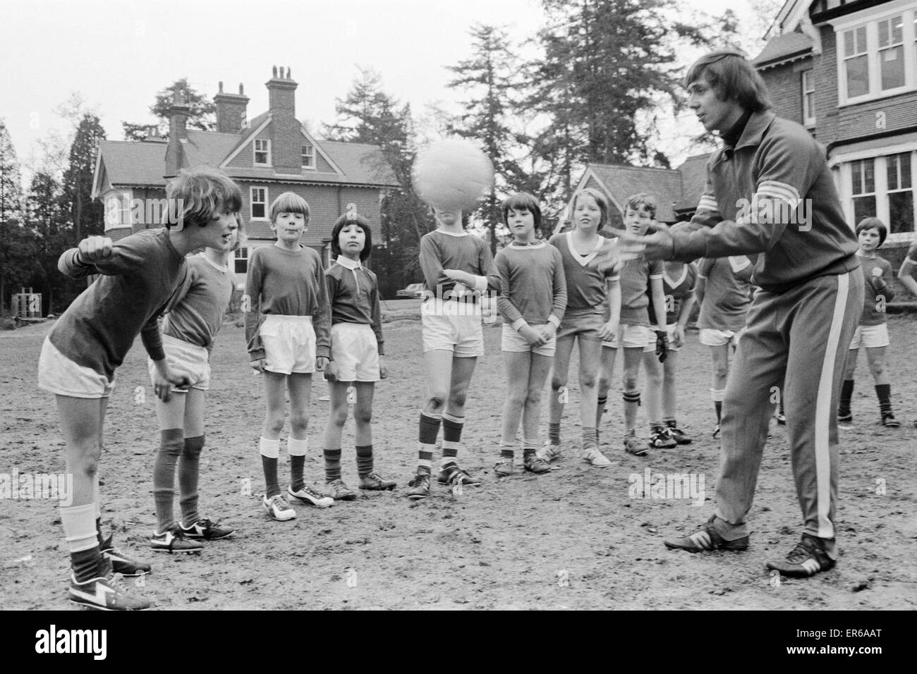 Queens Park Rangers calciatore Don Masson coaching i bambini a giocare a calcio a la Madonna degli Angeli Scuola di Crowthorne, Berkshire. Il 20 gennaio 1977. Foto Stock