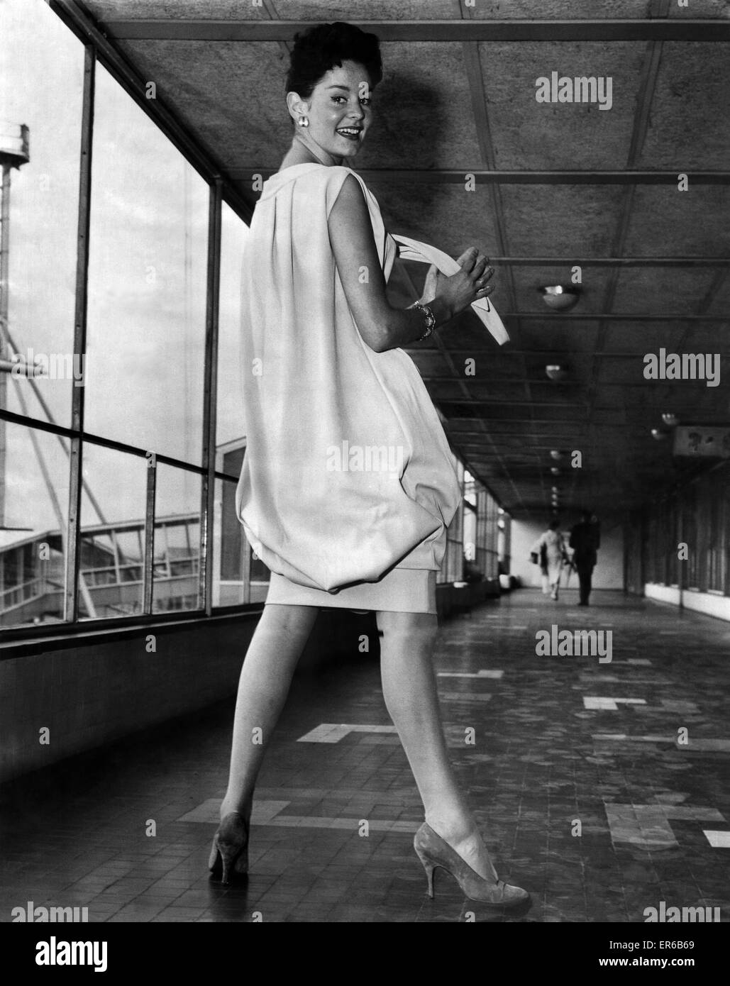 Abbigliamento Moda 1958: ecco una ragazza con il suo sacco ben legato… Modello Christina Griggs (sinistra), indossa un abito di sacco strettamente rifasciato in corrispondenza delle ginocchia. Giugno 1958 P021897 Foto Stock