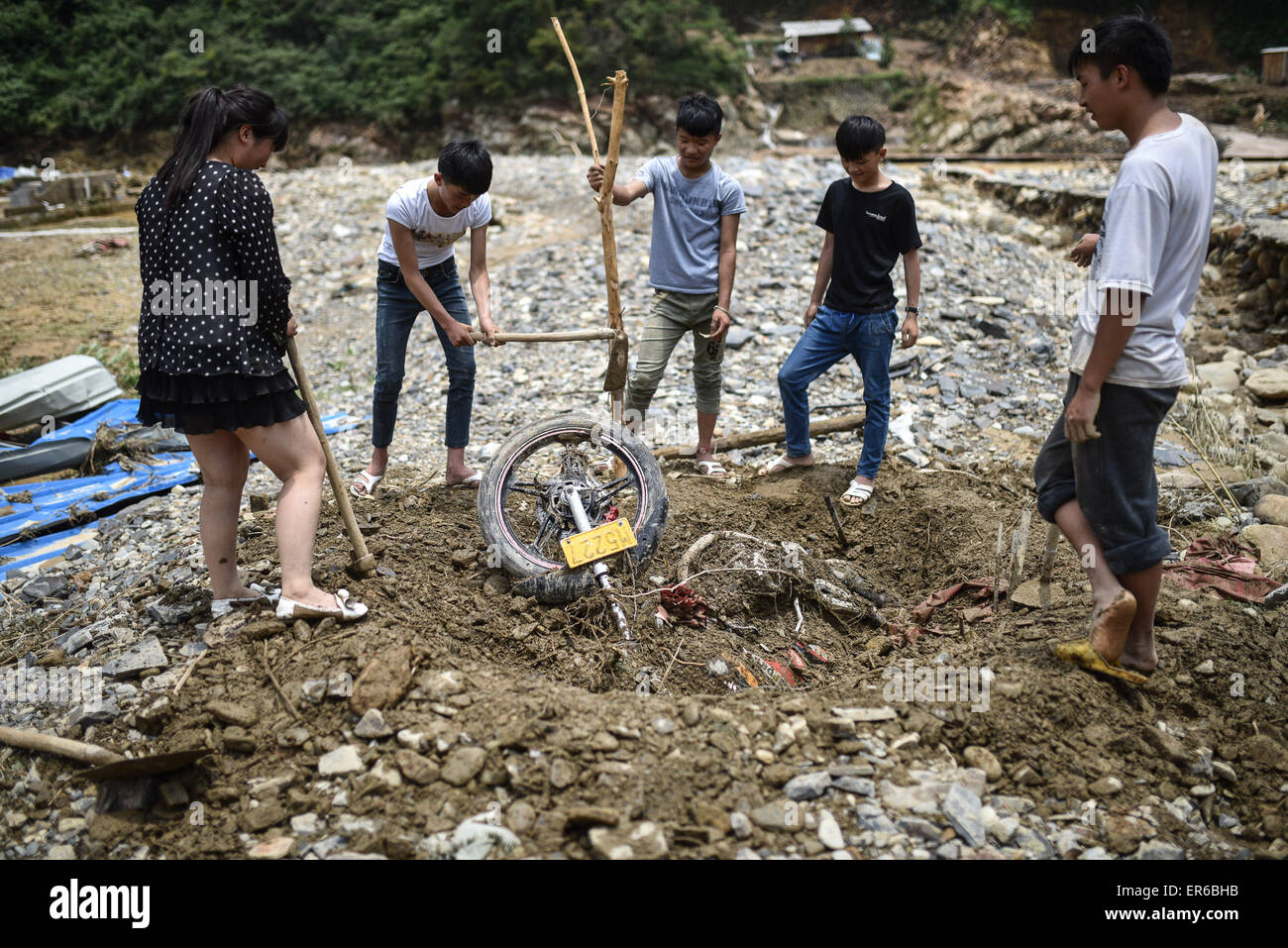 Leishan, della Cina di Guizhou. 28 Maggio, 2015. Gli abitanti dei villaggi locali di scavare un motociclo sepolta sotto il fiume fango in Datang township di Leishan County, a sud-ovest della Cina di Guizhou, 28 maggio 2015. Leishan, che è stata duramente colpita da acquazzone ha perso l'accesso al potere ed approvvigionamenti di acqua dopo la pioggia torrenziale ha flagellato la zona da martedì sera e mercoledì. © Liu Xu/Xinhua/Alamy Live News Foto Stock