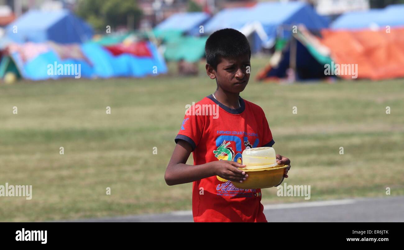 Kathmandu, Nepal. 28 Maggio, 2015. Un bambino porta il suo pasto alla sua tenda all'insediamento temporaneo a Kathmandu, capitale del Nepal, il 28 maggio 2015. Il governo del Nepal divieti da bambini che viaggiano senza i genitori o i tutori approvati per dissuadere i trafficanti di esseri umani. © Sunil Sharma/Xinhua/Alamy Live News Foto Stock