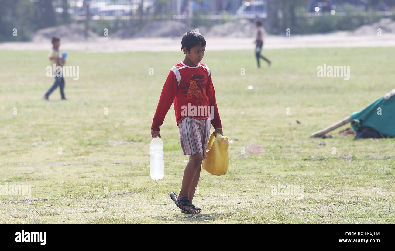 Kathmandu, Nepal. 28 Maggio, 2015. Un bambino porta bottiglie di acqua alla sua tenda all'insediamento temporaneo a Kathmandu, capitale del Nepal, il 28 maggio 2015. Il governo del Nepal divieti da bambini che viaggiano senza i genitori o i tutori approvati per dissuadere i trafficanti di esseri umani. © Sunil Sharma/Xinhua/Alamy Live News Foto Stock