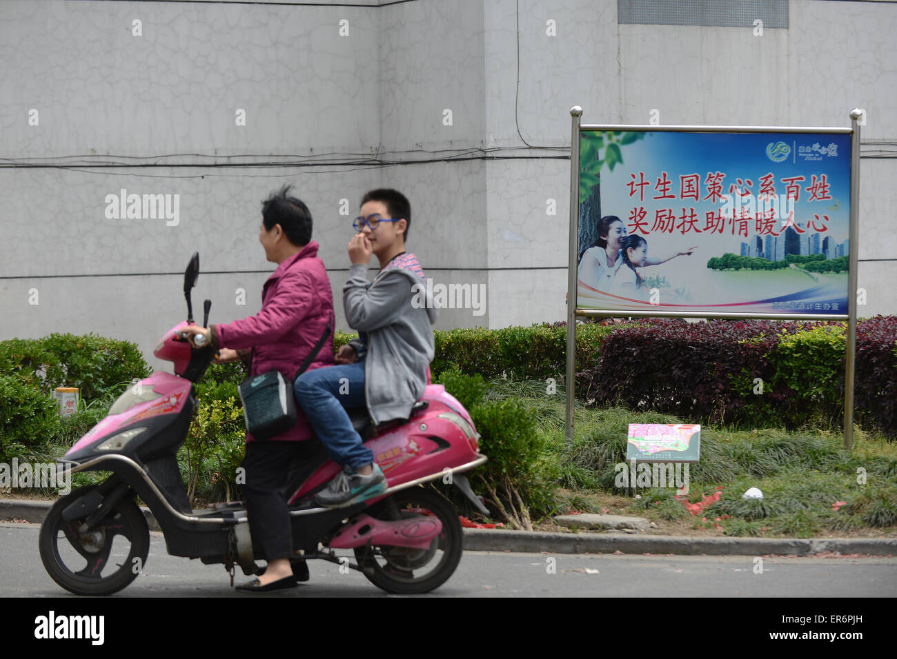 Jiaxing, Zhejiang, Cina 9 Maggio 2015-- Zhiling Chu aziona una bicicletta elettrica con il nipote Chengcheng . Ci sono circa oltre 1 milioni di famiglie hanno perso le loro solo un bambino in Cina. Secondo la Cina media, ci sono 190 milioni di 15-30 anni di persone che sono un solo bambino nella loro famiglia e ci sono oltre 2 milioni di persone anziane che hanno perso il loro solo un bambino. Essa è aumentata 78.000 famiglie ogni anno. Oltre 2 milioni di cittadini anziani perso il loro unico figlio. Un bambino di una politica della famiglia è stato realizzato dal 1982. Foto Stock